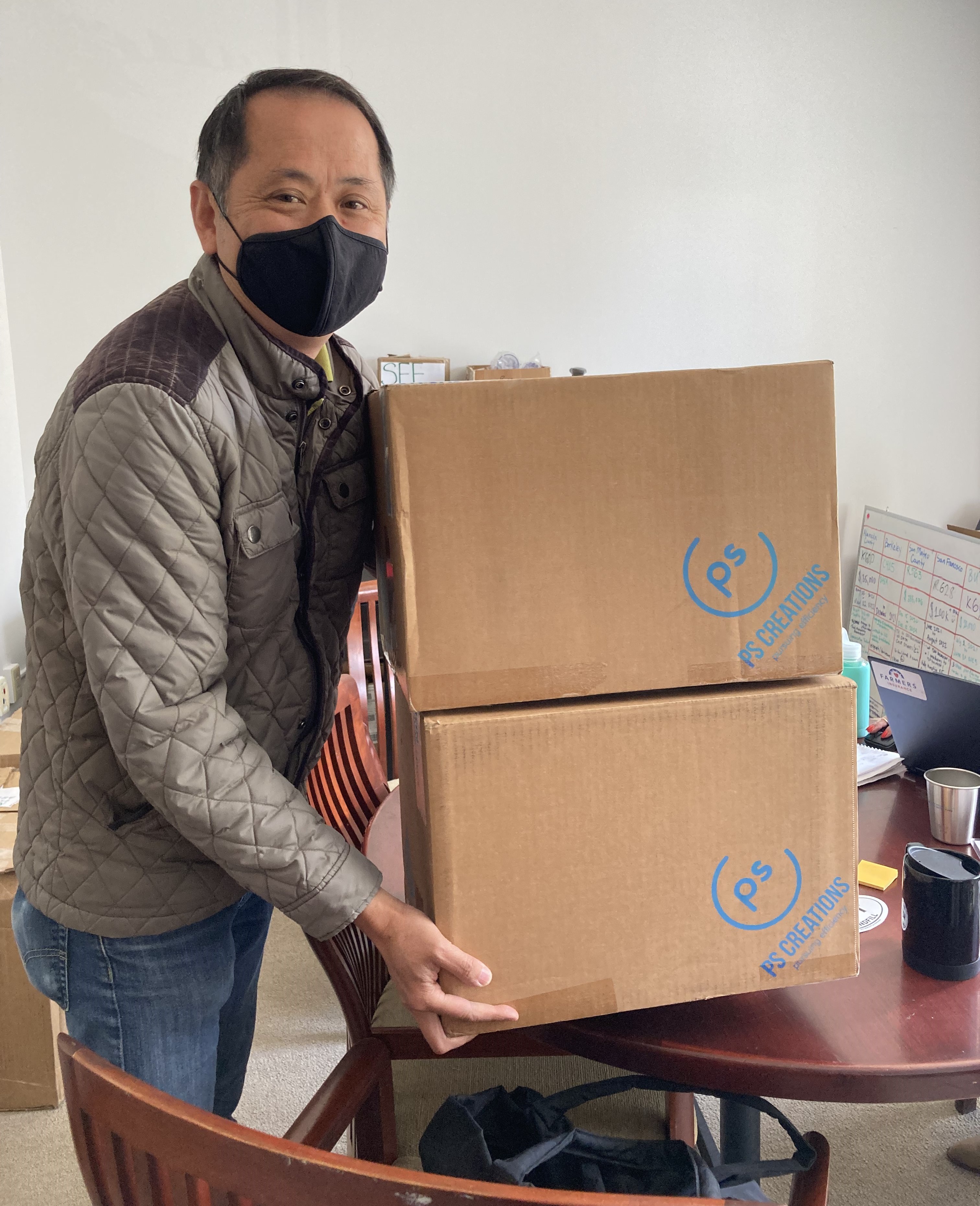 ReThink Disposable staff poses with box full of reusable dishware being delivered to a local business