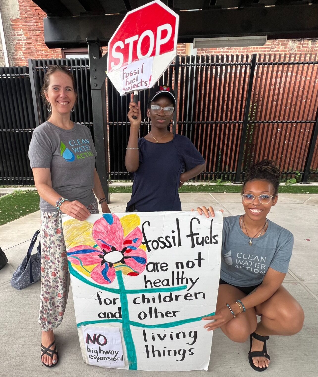New Jersey Clean Water staff wtih signs: "Stop Fossil Fuels" "Fossil Fuels are not healthy for children and other living things"