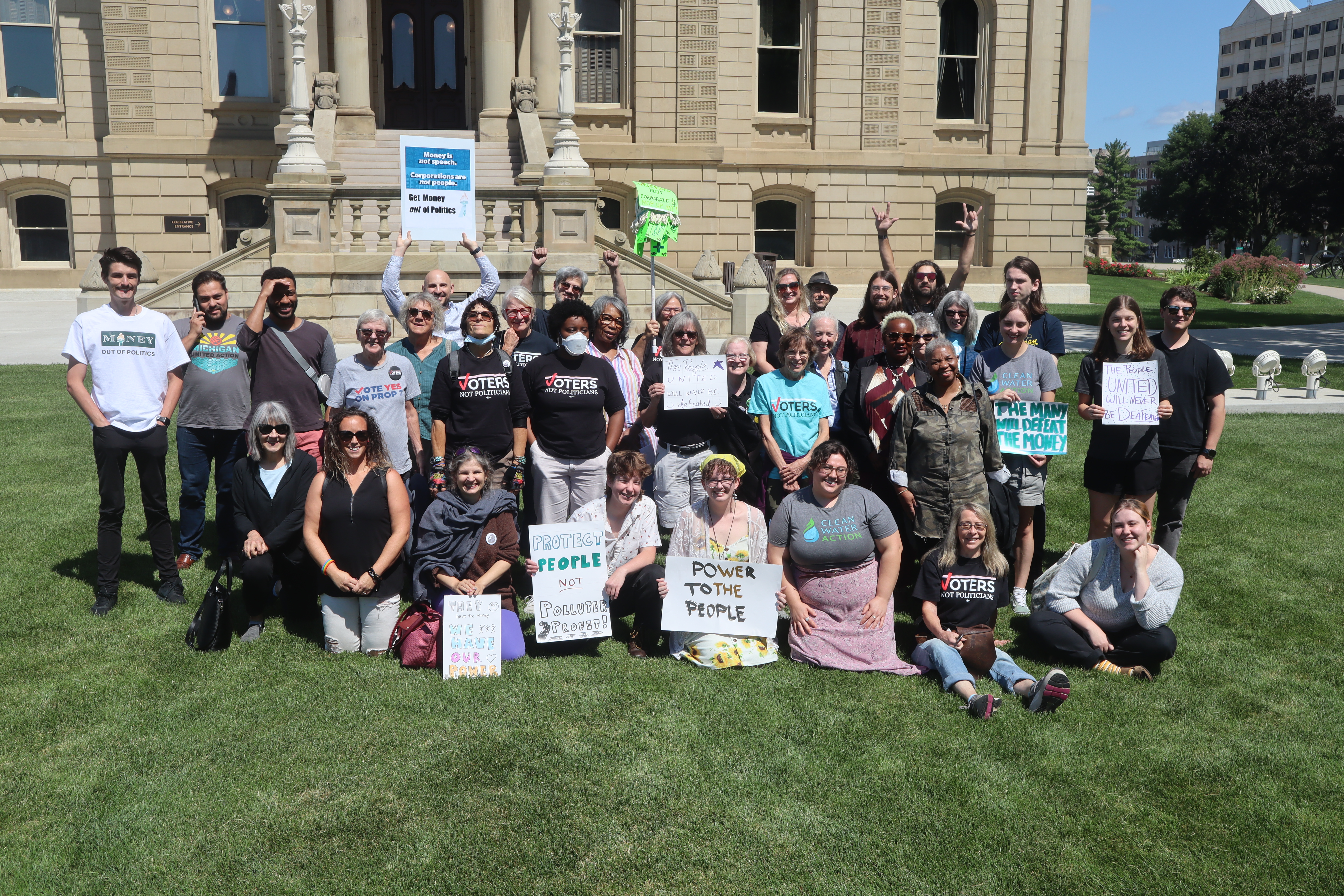 Large group of MMOP supporters posing on the Michigan Capitol Lawn across the street from the State Board Of Canvassers meeting.