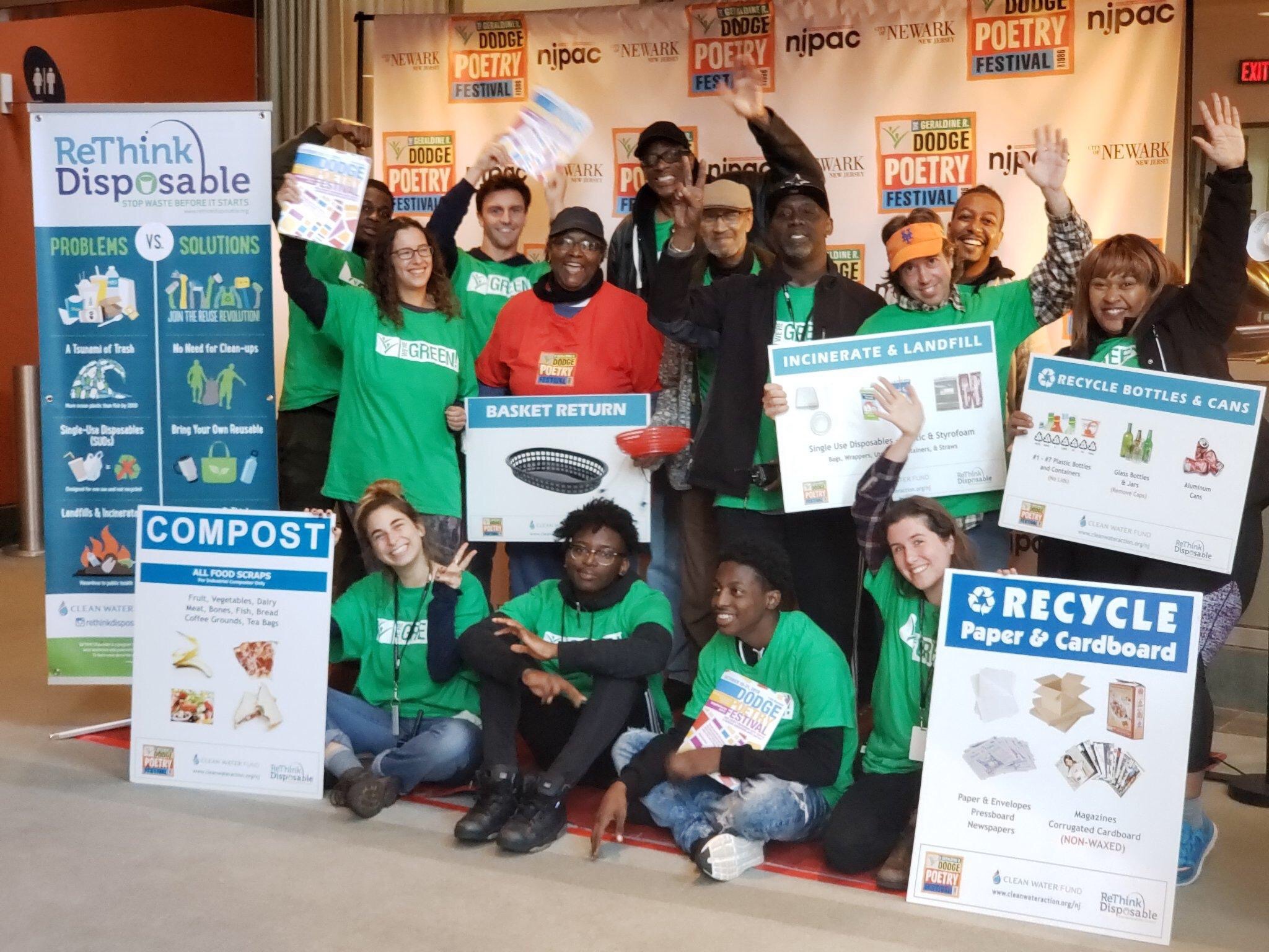 Crowd posing with ReThink Disposable information and recycling/compost educational signs