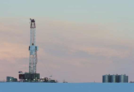 Picture of a drilling rig on a snowy landscape at dawn
