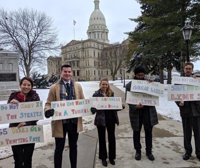 Michigan canvass staff holding shut down line 5 / no tunnel signs outside Lansing capitol building in 2018. Credit: Jennifer Schlicht