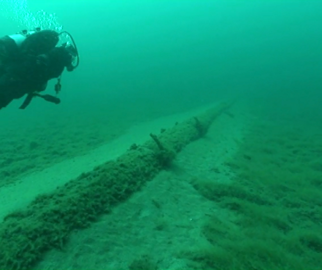Shot of diver underwater alongside an unsupported section of the Line 5 Pipeline. Credit National Wildlife Federation
