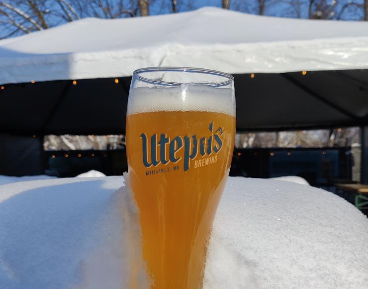 Beer pint glass from Utepils Brewing in a snowdrift