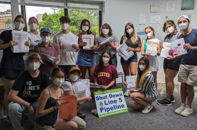 Clean Water Action staff posing with letters against the Line 5 pipeline