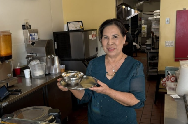 Owner of Korean Palace showing off new stainless steel plates and bowls