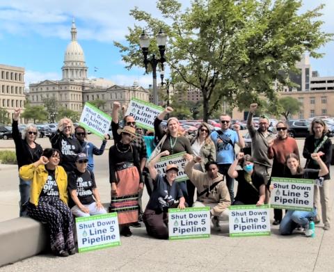 Outside the Michigan capitol building with Shut Down Line 5 Pipeline signs
