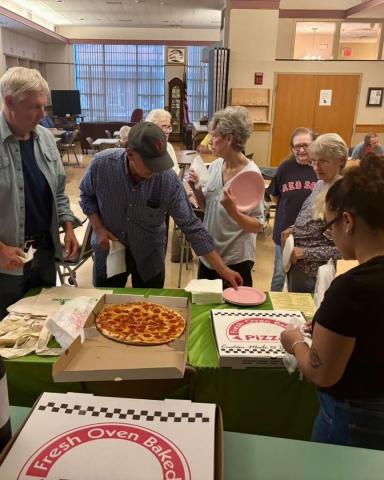 Serving pizza at a Mass Save event hosted by Clean Water Action