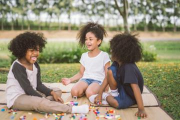 kids in a field - canva