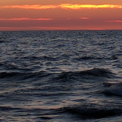 Dark blue Lake Superior waves with red sunset on horizon. Credit Jennifer Schlicht 