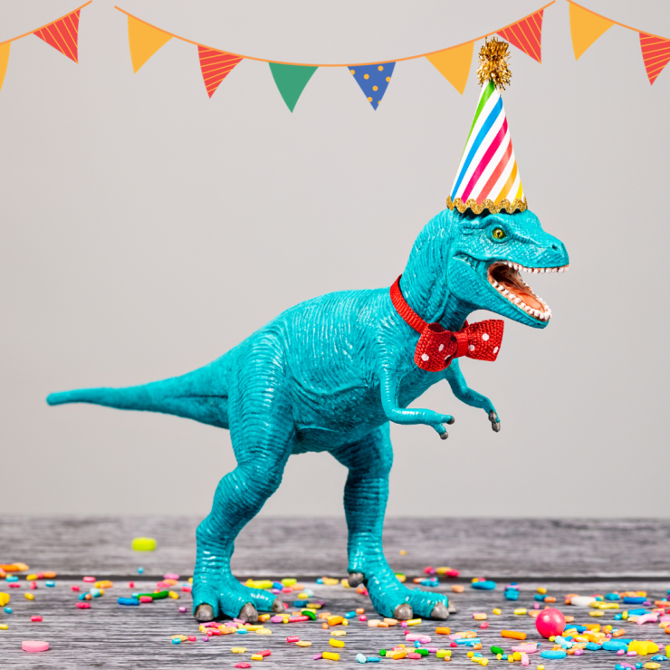 Image of a plastic dinosaur with a party hat on.