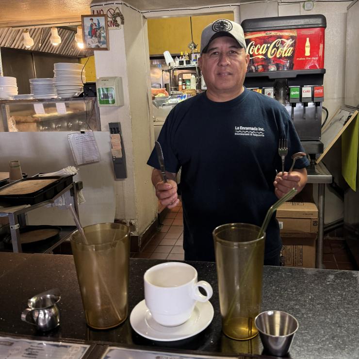 Owner of La Enmarada showing off the new reusable cups and utensils