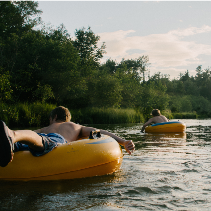A family tubing on a river with text: What’s in Our Water Is in Our Brains: A Minnesota Perspective for Brain Awareness Week