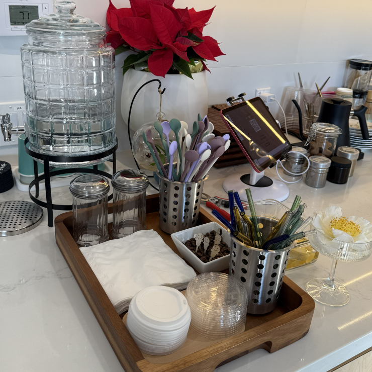 Cafe self-serve station with reusable items like silicone stirrers and glass straws