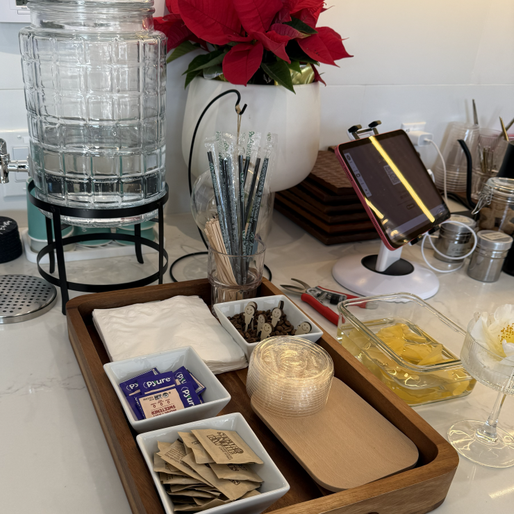 Cafe self-serve station with single-use items like wooden stirrers and sweetener packets