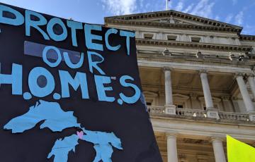 Sign outside Michigan capitol: Protect our H.O.M.E.S., with image of the Great Lakes. Credit Jen Schlicht