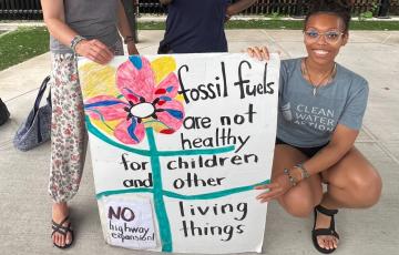 New Jersey Clean Water staff wtih signs: "Stop Fossil Fuels" "Fossil Fuels are not healthy for children and other living things"