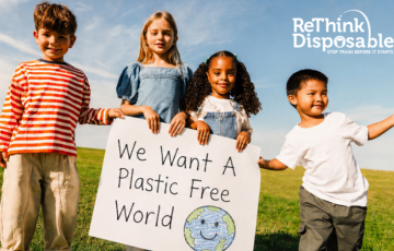 Kids holding sign that says We Want a Plastic Free World