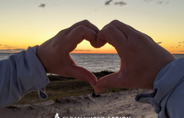 Hands making heart symbol in front of Lake Michigan