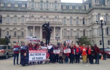 Over 30 Baltimore residents outside of City Hall wearing red in support of the Oil Trains Ordinance