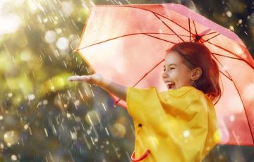 Photo of girl laughing under an umbrella in the rain
