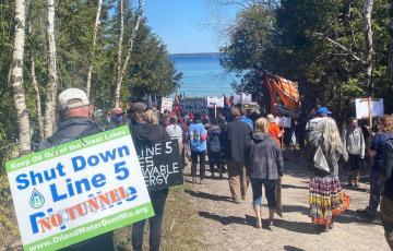 Crowd marching on Lake Michigan with Shut Down Line 5 Signs