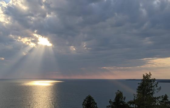 Sunlight streaming through break in clouds and reflecting on Lake Michigan surface