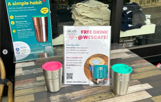 Display with signs explaining OKAPI reusable cups at Wescafe in Alameda California