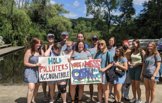 Clean Water Canvass Staff with "Hold Polluters Accountable" and "Make A Mess Clean It Up" signs