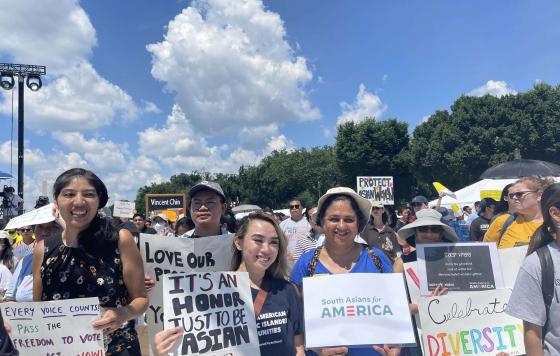 2022 APIAVote Unity March Attendees with signs: Every voice counts, pass the freedom to vote act now - It's an honor just to be Asian - South Asians for America - Celebrate Diversity