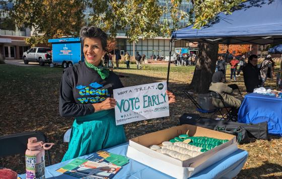 Clean Water Mid MI Organizer Dr Nichole Keway Biber holding a vote early sign on MSU campus