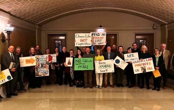 People holding signs like "PFAS Are Forever, Life Is Not" at a rally in the MN State Capitol