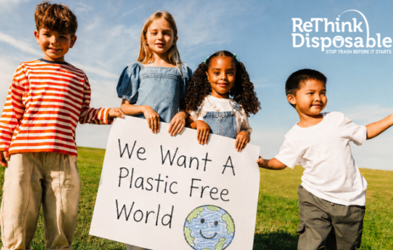Kids holding sign that says We Want a Plastic Free World