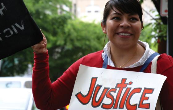 A young woman holding a saign that says justice