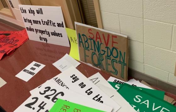 Photo of protest signs at public hearing. Courtesy of Patch.com